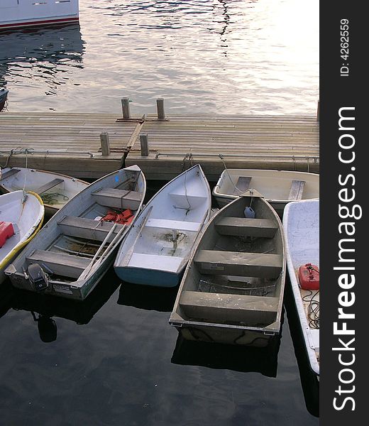 Rowboats rest in the harbor in Maine at dusk. Rowboats rest in the harbor in Maine at dusk