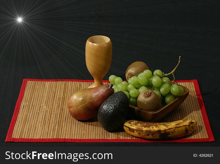 Arrangement of fruit with pear, grapes, kiwi, and others with wooden cup. Arrangement of fruit with pear, grapes, kiwi, and others with wooden cup