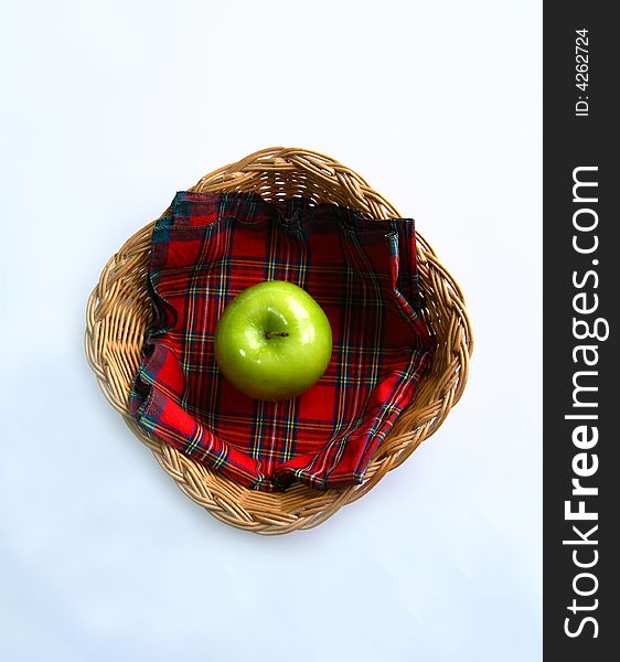 Green apple on a napkin in a straw basket. Green apple on a napkin in a straw basket