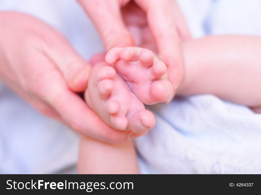 Mother hold baby leg in hand
