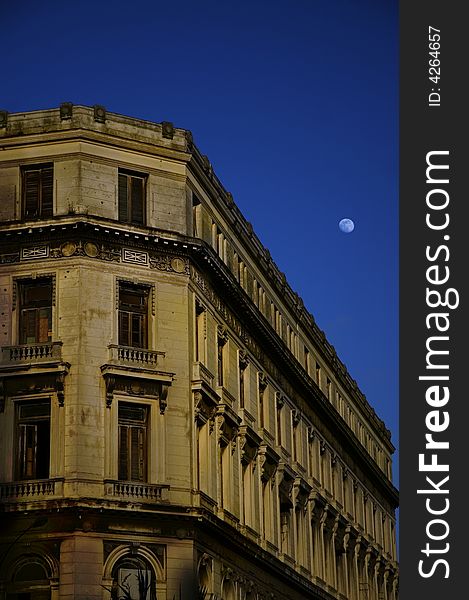 Old building facade in Havana - central park at dusk with early moon. Old building facade in Havana - central park at dusk with early moon