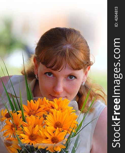 Woman with orange flowers look at camera. Woman with orange flowers look at camera
