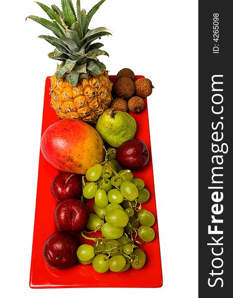 Assortment of fresh fruit arranged on a bright red serving dish. Assortment of fresh fruit arranged on a bright red serving dish.