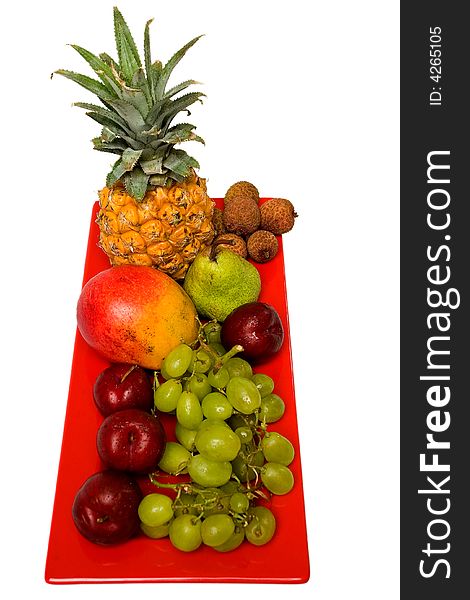 Assortment of fresh fruit arranged on a bright red serving dish. Assortment of fresh fruit arranged on a bright red serving dish.