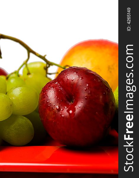 Assortment of fresh fruit arranged on a bright red serving dish. Assortment of fresh fruit arranged on a bright red serving dish.