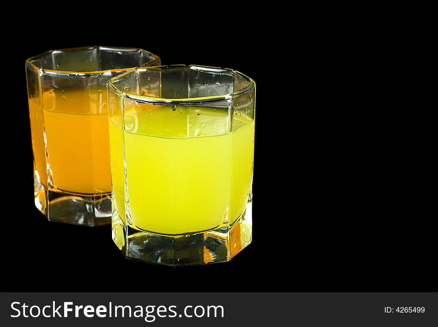 Two glass with colored liquid isolated on black