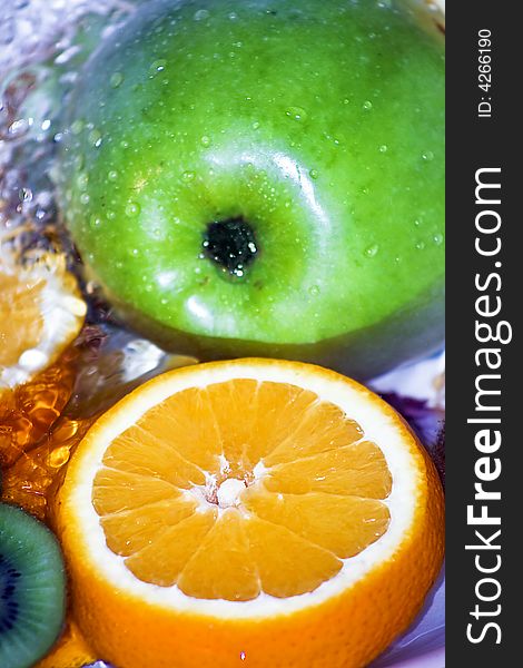 Green apple and orange slice in fresh water