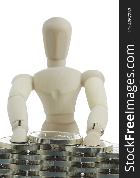 Manikin standing behind and building financial wall. Close-up. Focus on coins. Manikin standing behind and building financial wall. Close-up. Focus on coins