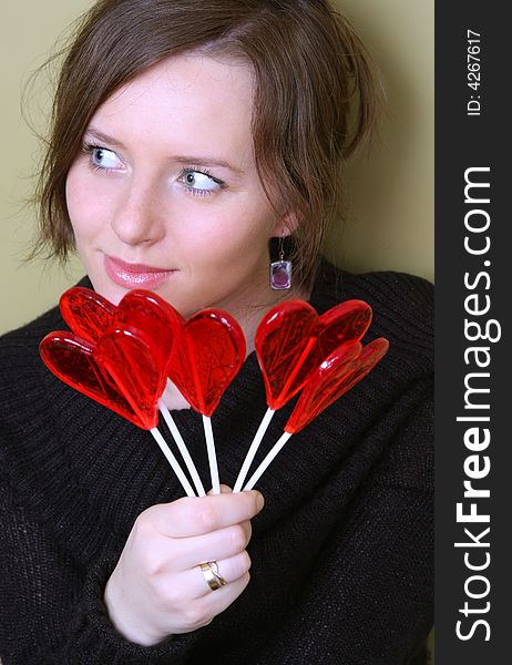 Valentine girl is holding lollipops in palm