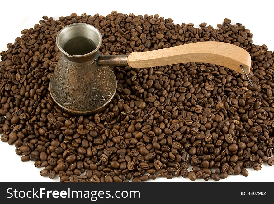Cezve (ibrik) on a heap of coffee beans. Cezve (ibrik) on a heap of coffee beans