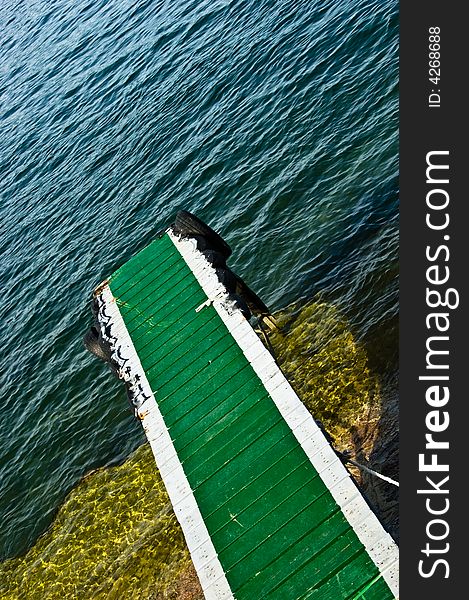 A green ramp leading to a lake.