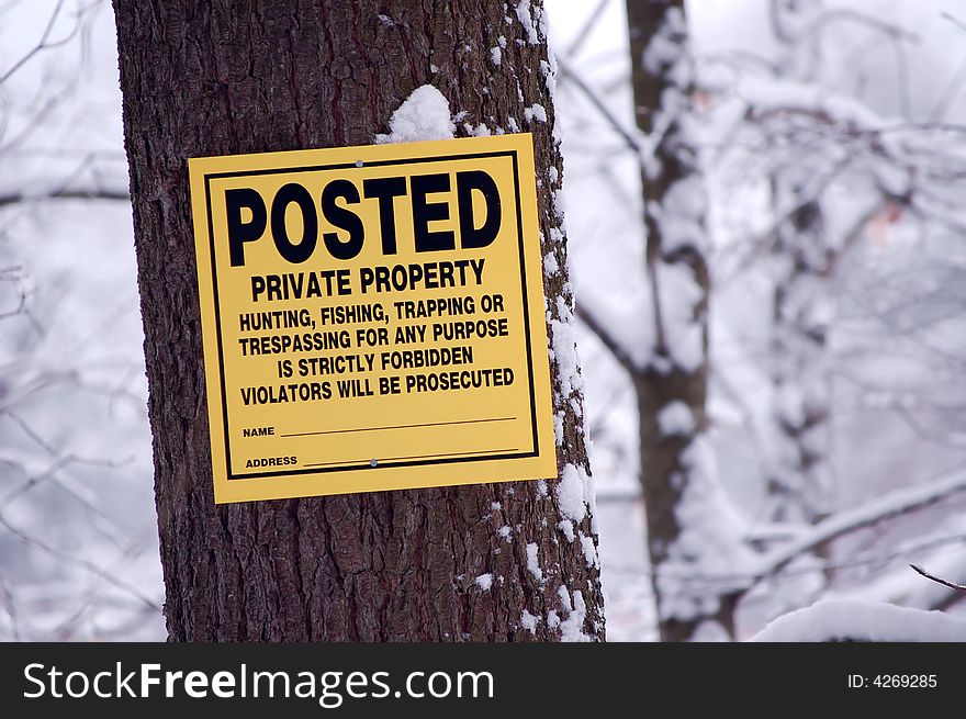 A yellow sign reading POSTED private poroperty. Hunting, fishing, trapping, or trespassing for any reason is strictly forbidden. Violators will be prosecuted. A yellow sign reading POSTED private poroperty. Hunting, fishing, trapping, or trespassing for any reason is strictly forbidden. Violators will be prosecuted.