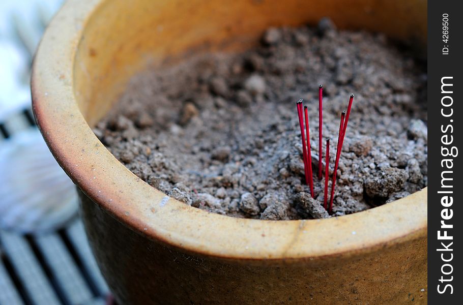 A few joss sticks left behind in a pot of soil. A few joss sticks left behind in a pot of soil