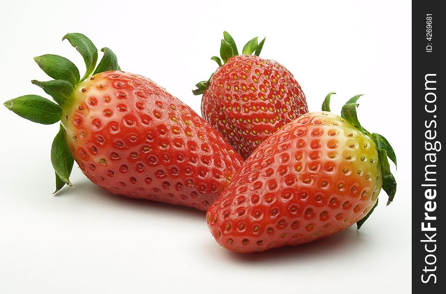 Three red strawberries isolated on white