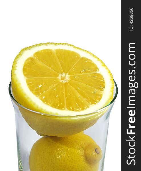 Two parts of yellow ripe lemon in the glass on white background. Two parts of yellow ripe lemon in the glass on white background