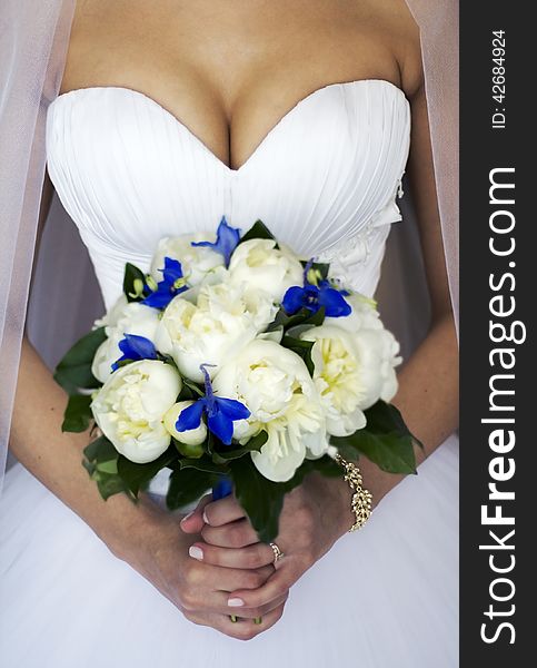 Hands of a bride with a bouquet