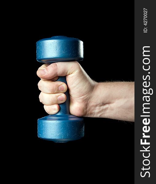 Dumbbell in a hand on a black background.