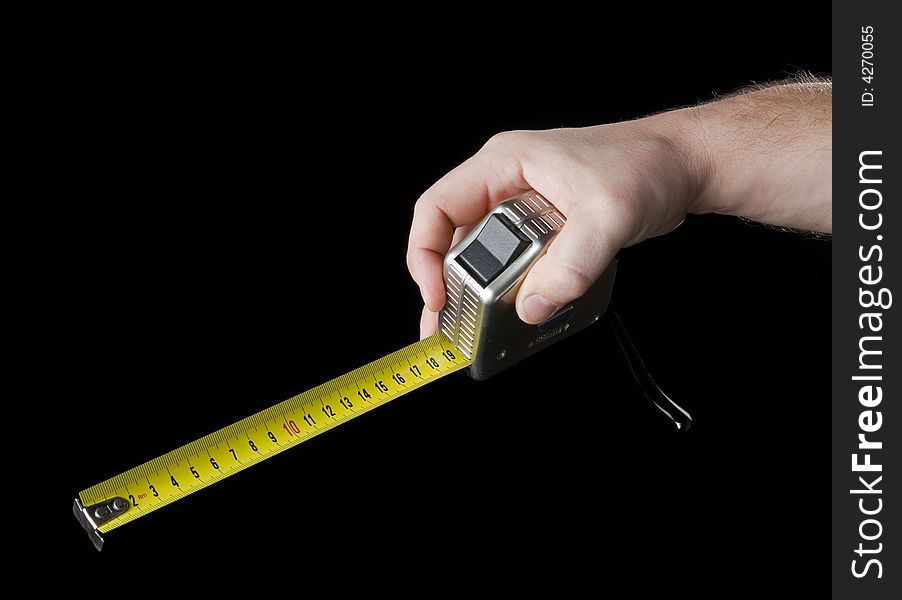 Measuring tape in hand. Isolated on a black background.