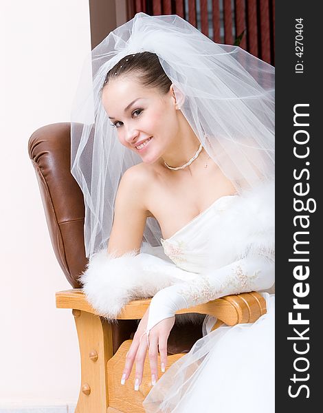 A beautiful smiling bride in a chair. A beautiful smiling bride in a chair