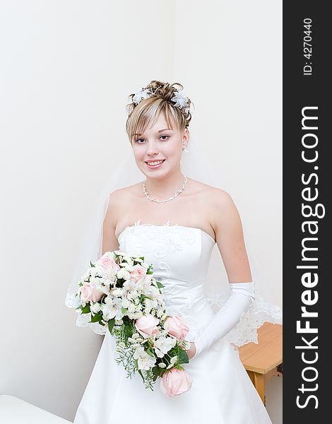 A beautiful happy bride with a flower bouquet
