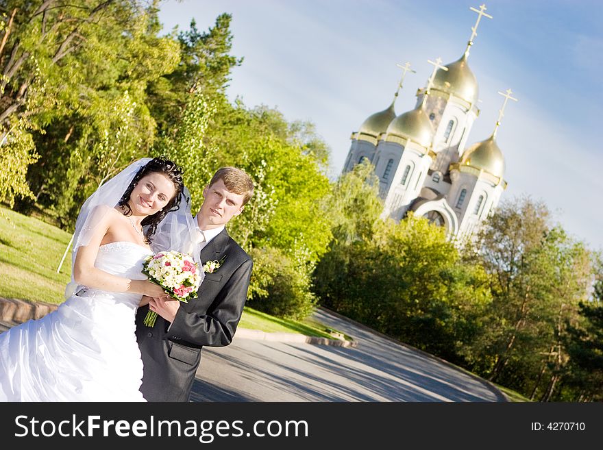 A happy bride and a groom near the church