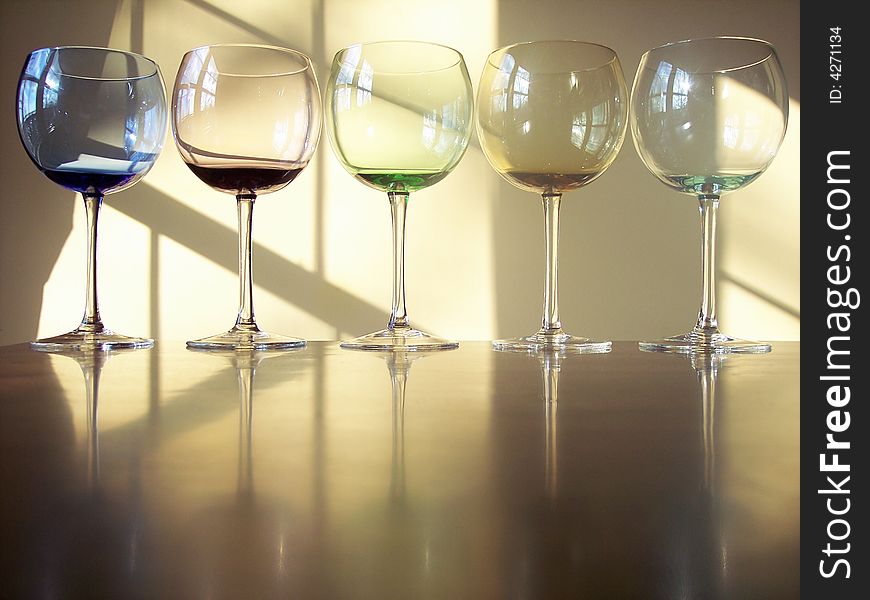 Different colored wine glasses arranged in different formations