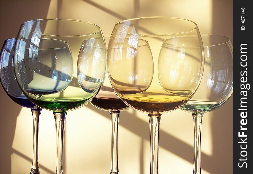 Different colored wine glasses arranged in different formations