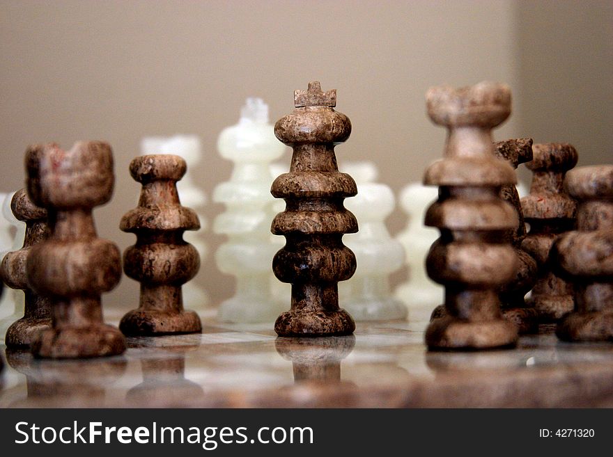 This is an image of several marble chess pieces sitting on a chess board. This is an image of several marble chess pieces sitting on a chess board.