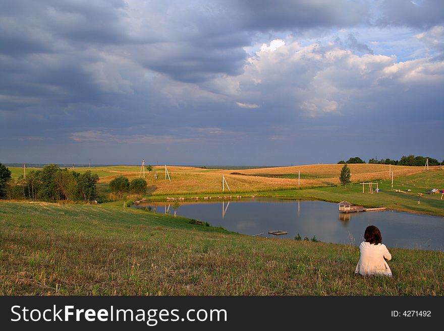 Woman sitting on the top of the hill at the morning time. Woman sitting on the top of the hill at the morning time