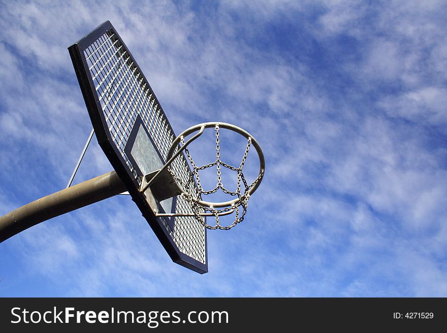 Basketball hoop and backboard set against a blue sky