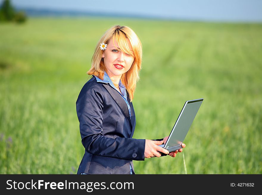 Girl with laptop stay on meadow