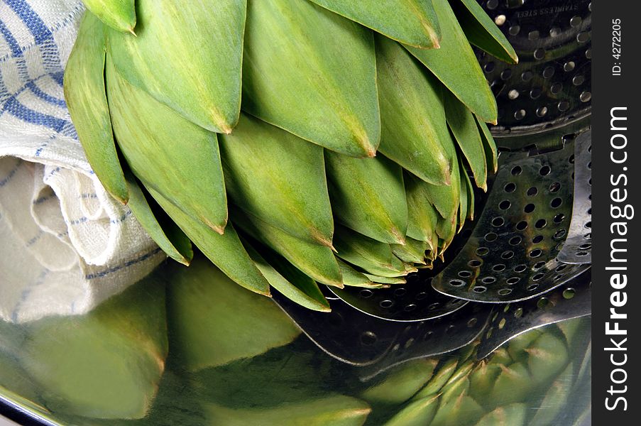 Close up of an artichoke in a steamer.