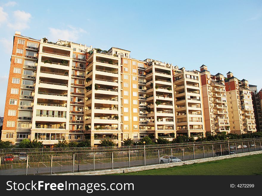 An luxury apartment block with railings,meadows surrounded.blue sky and clouds.Foshan,Guangdong,China.