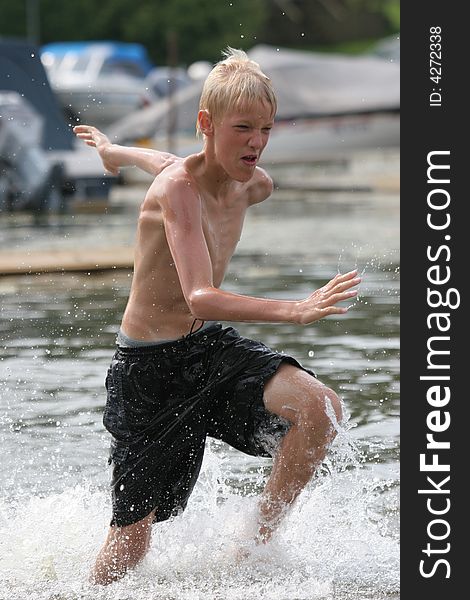 Boy running in shallow water. Boy running in shallow water