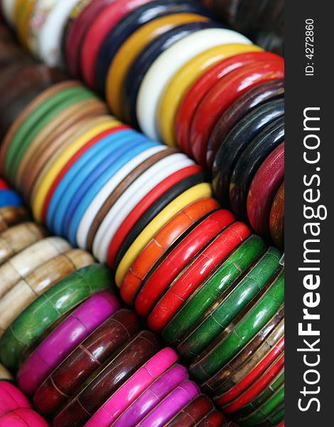 Rows of colorful wooden bracelets - shallow DOF.