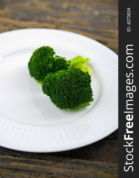 Green steamed broccoli on a white plate