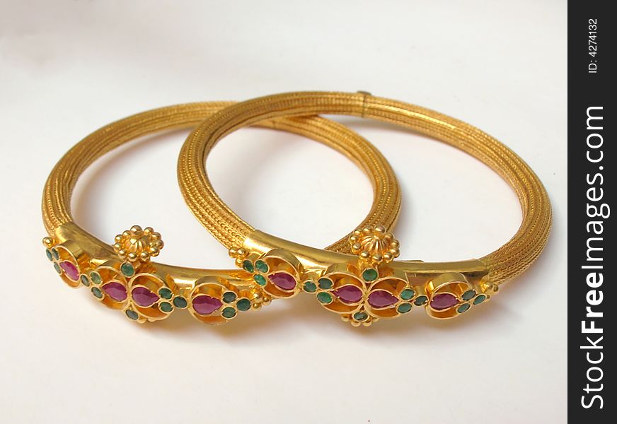 A close up of Two Gold Bangles on white