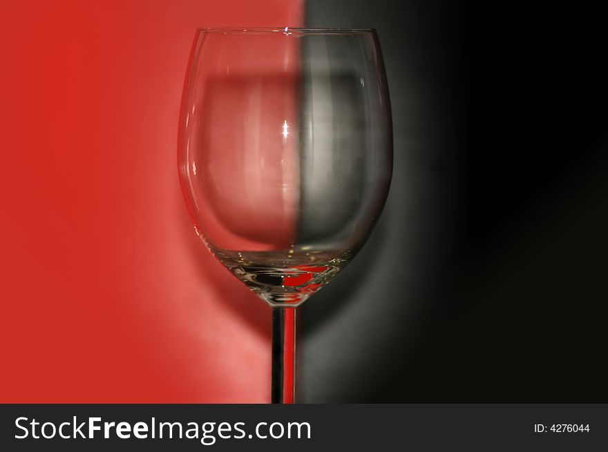 Dishware. empty wineglass on red & black background