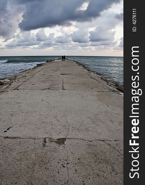 Breakwater under dramatic sunset sky