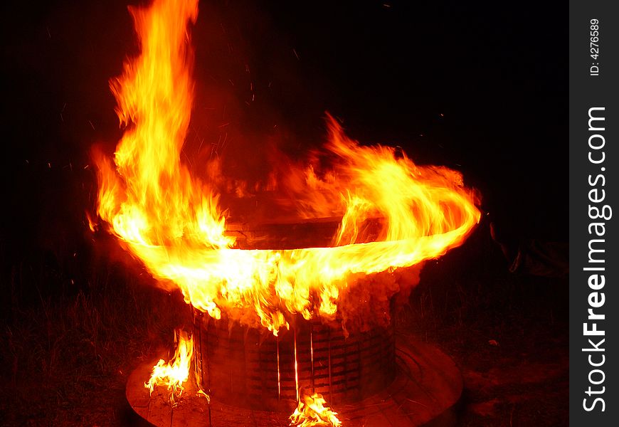 Bright flame of the burning wooden coil on a background of years night. Bright flame of the burning wooden coil on a background of years night