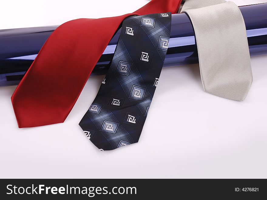 Ties over dark blue pipe on white background