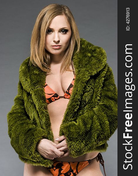 Attractive blonde model wearing green fur and bikini with green make-up. Attractive blonde model wearing green fur and bikini with green make-up