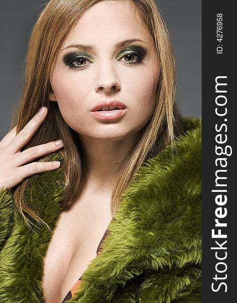 Attractive blonde model wearing green fur with green make-up. Attractive blonde model wearing green fur with green make-up