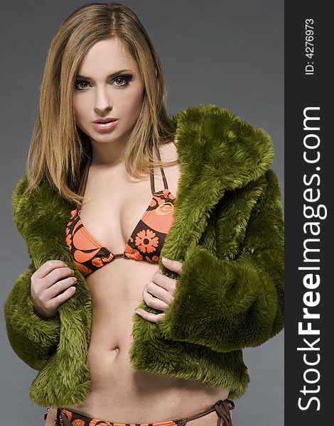 Attractive blonde model wearing green fur and bikini with green make-up. Attractive blonde model wearing green fur and bikini with green make-up