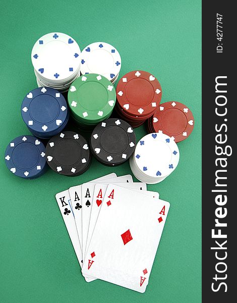 Poker playing cards four aces with chips on green background