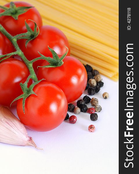 Close up of tomatoes, garlic, pepper and spaghetti, over white. Close up of tomatoes, garlic, pepper and spaghetti, over white