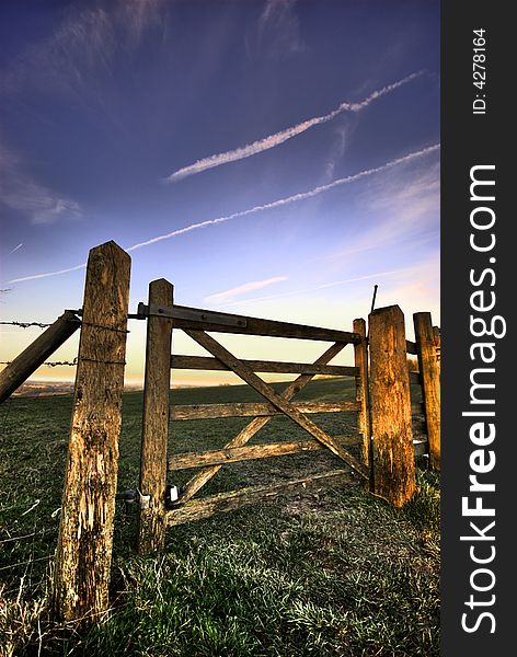 A wooden gate leading to a field on the South Downs in southern England. A wooden gate leading to a field on the South Downs in southern England