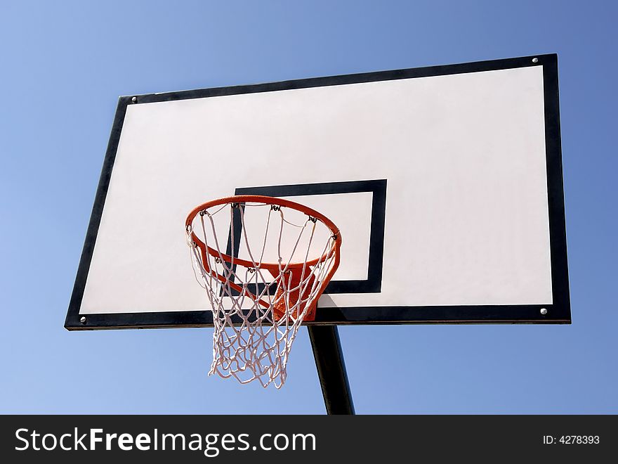 Outdoor basketball hoop against the blue sky