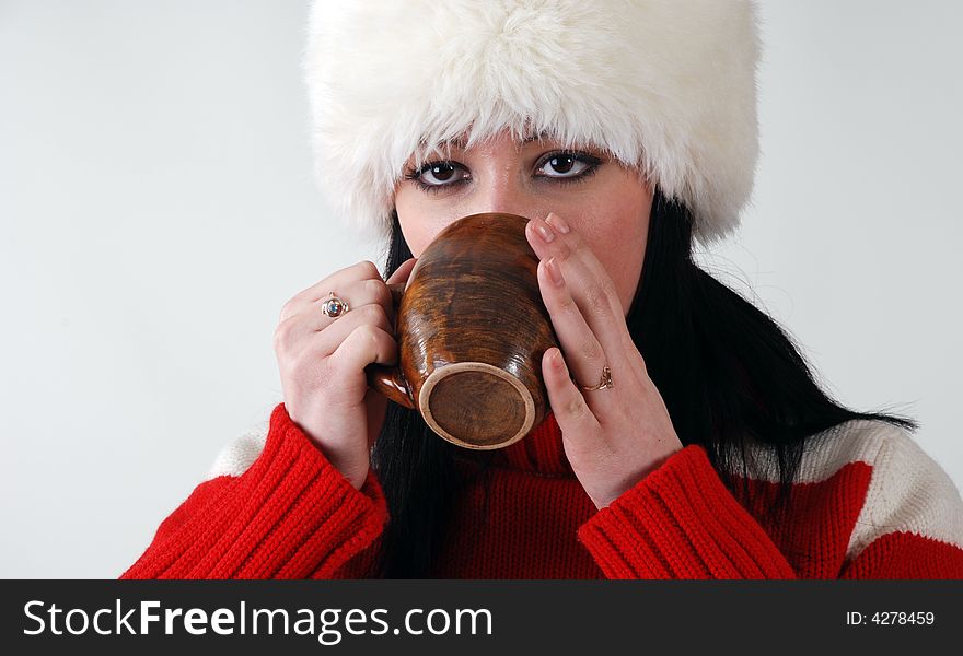 Young girl in fluffy hat with hot drink. Young girl in fluffy hat with hot drink