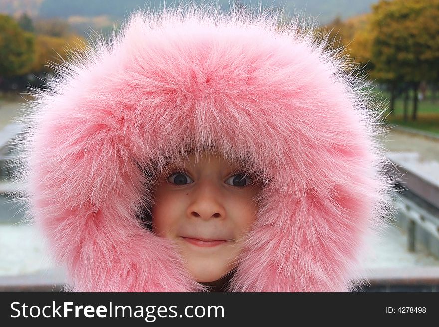 Portrait of a young girl in a hood of fur trimmed pink jacket. Portrait of a young girl in a hood of fur trimmed pink jacket.